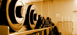 Hanteln auf einem Hantelständer im Fitnessstudio für einem Spiegel